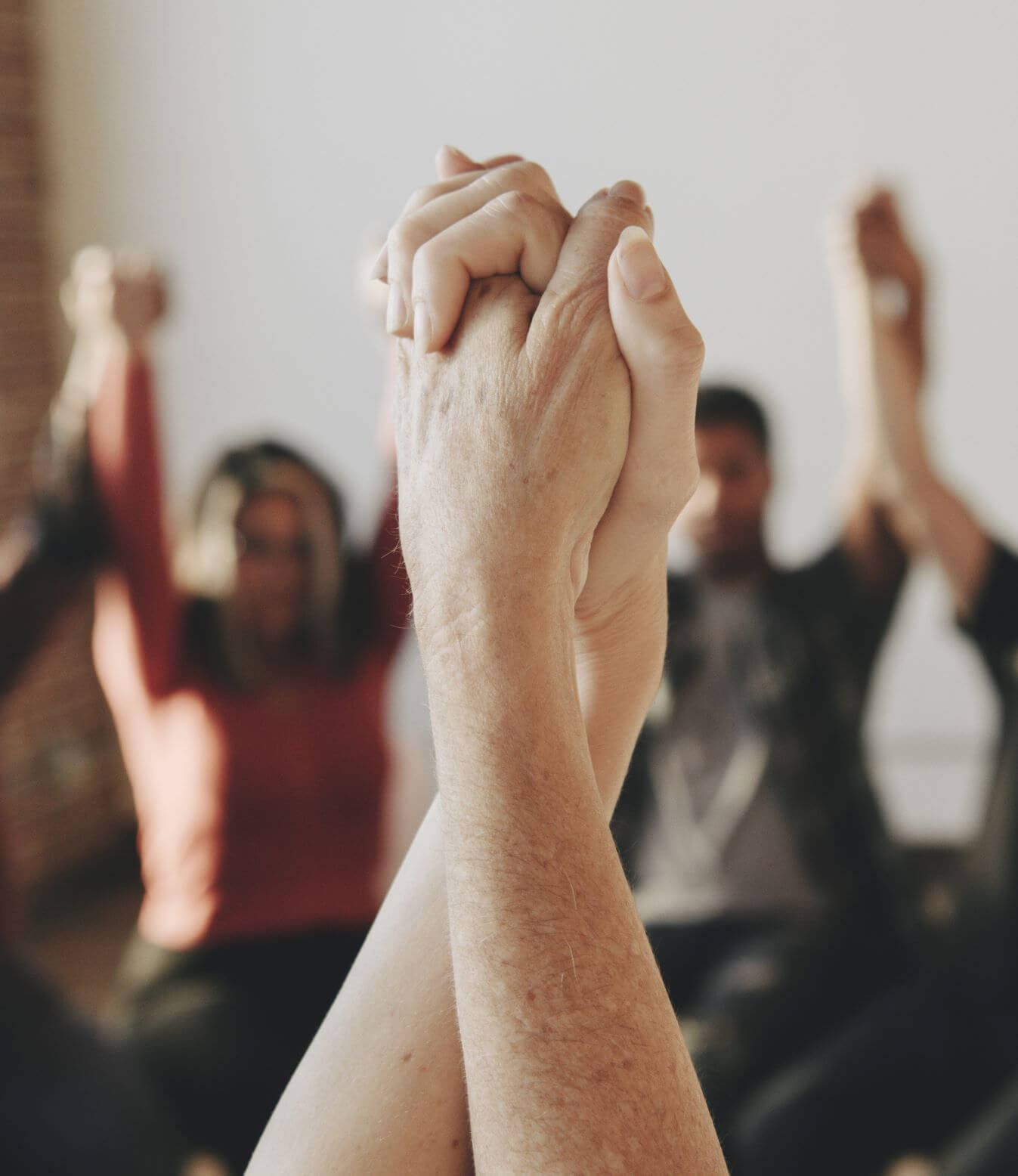 People holding hands in a group counselling session
