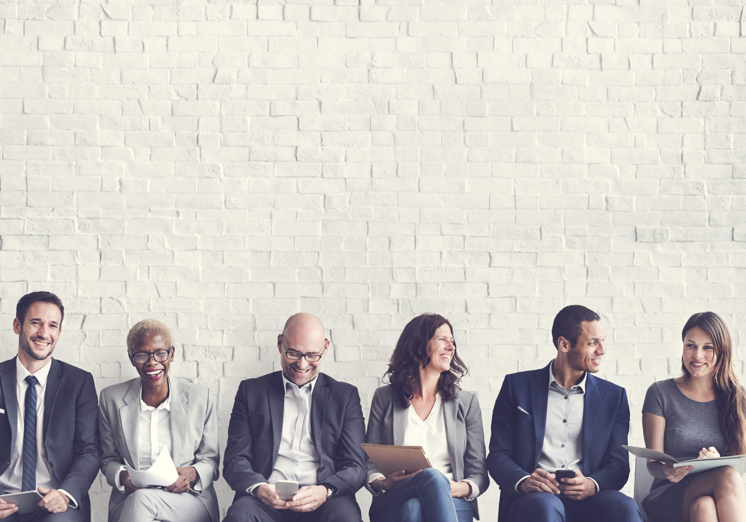 Group of professionals sat in a line smiling